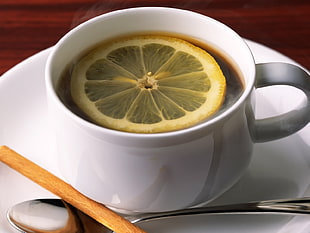 brown tea with slice of lemon in white ceramic mug